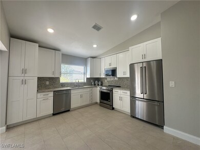 Kitchen with lofted ceiling, sink, stainless steel
