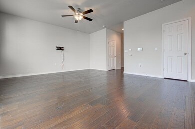 Unfurnished room with a ceiling fan, dark wood-ty