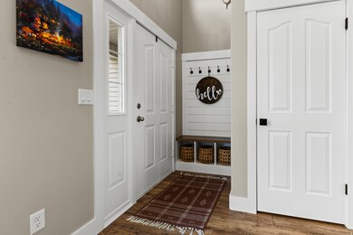 Mudroom with dark wood-style flooring and baseboards