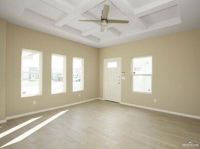 Empty room with beam ceiling, coffered ceiling, light wood-style flooring, and baseboards