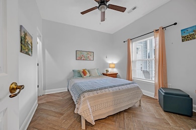 Bedroom with visible vents, a ceiling fan, and bas