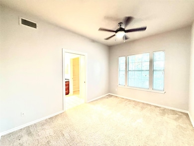 Unfurnished room featuring light carpet and a ceiling fan