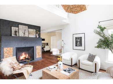 The double-height living room is anchored by a gas fireplace and walls of glass leading outdoors.