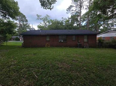 Rear view of house featuring brick siding and central air condition unit