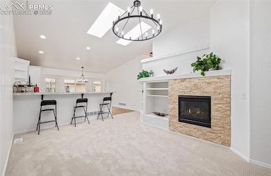 Carpeted living room with a fireplace and lofted c
