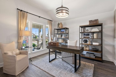 Office space featuring dark wood-style flooring and vaulted ceiling