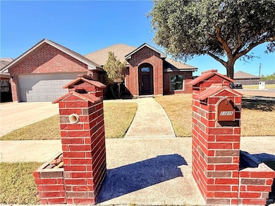 Single story home with brick siding, driveway, an attached garage, a front yard, and a shingled roof