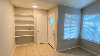 Entryway with light tile patterned floors and a t