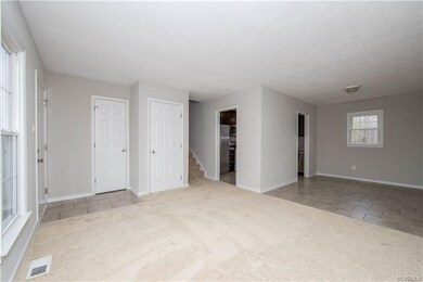 tiled entryway with carpeted living room floors an