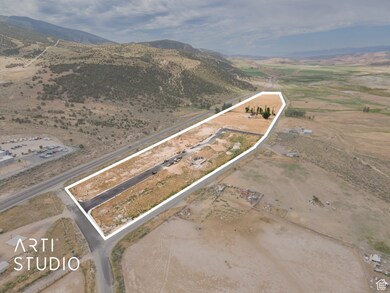 Aerial view of property and surrounding area with property parcel outlined, rural landscape, and a mountainous background