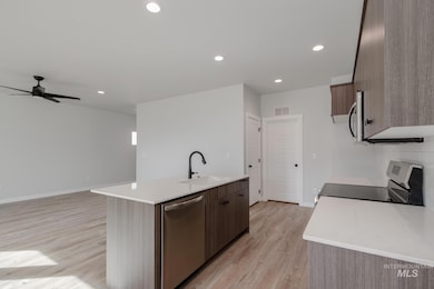 Kitchen with stainless steel appliances, light stone counters, modern cabinets, and recessed lighting