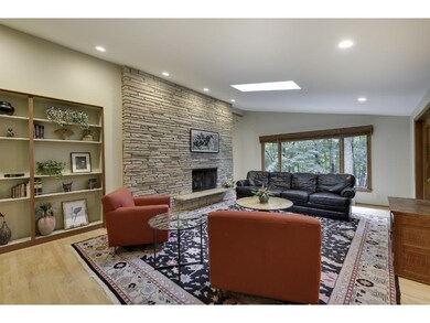 The living room features floor to ceiling wood bur