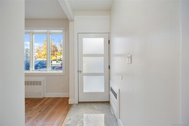 Entryway featuring radiator heating unit and wood finished floors