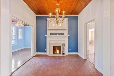 Unfurnished living room featuring baseboards, wood