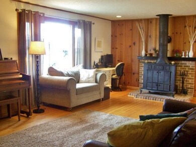Living Room with hardwood floors, cozy wood furnac