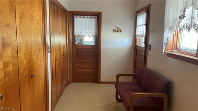 Corridor featuring light colored carpet