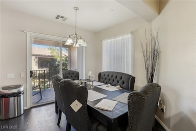 Dining area featuring dark wood-style floors and a chandelier