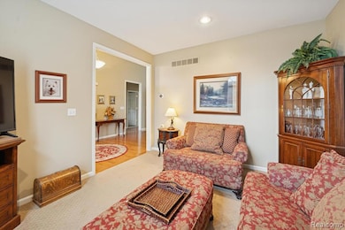 Inviting front sitting room with neutral paint tones, and soft natural lighting.