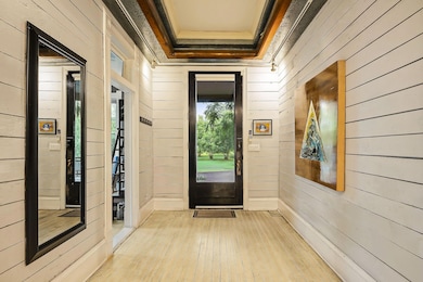 Entryway featuring hardwood / wood-style floors, wood walls, crown molding, and a relaxing sauna
