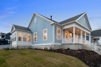 View of property exterior with a shingled roof, a sunroom, stairs, and covered porch