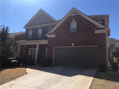 View of front facade featuring a garage, concrete driveway, and brick siding