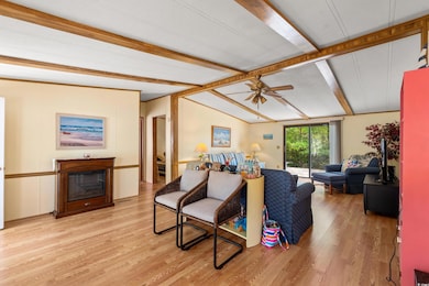 Living room with ceiling fan, lofted ceiling with 