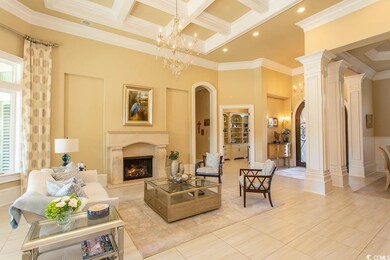 Living room featuring a premium fireplace, beam ceiling, a high ceiling, arched walkways, and coffered ceiling