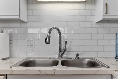 Kitchen featuring white cabinetry, backsplash, and