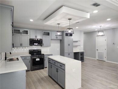 Kitchen with electric range, kitchen island, and decorative light fixtures