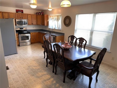 Dining room featuring light flooring and baseboards
