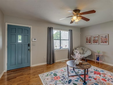 Sitting room with original wood floors and a ceiling fan