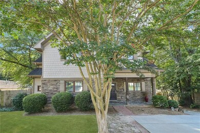 View of front of home featuring stone siding and roof with shingles