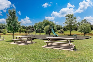 View of community featuring a playground and a yar