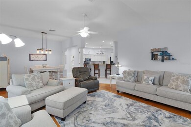 Living room has volume ceilings, wood floors & plantation shutters