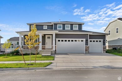 View of front facade with stone siding, driveway, a front lawn, and an attached garage