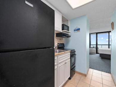 Kitchen with tasteful backsplash, light tile patte