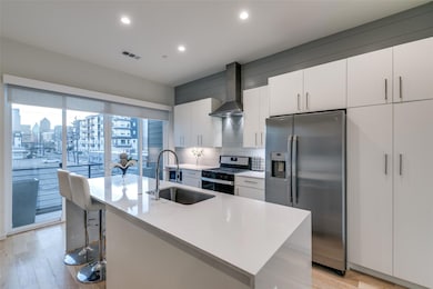 Kitchen with a sink, wall chimney exhaust hood, st