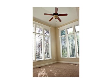 Floor to ceiling windows fill the den/sun room wit