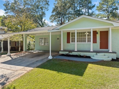 View of front of house with a carport and a front lawn