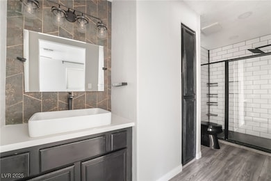 Bathroom featuring a shower stall, vanity, toilet,