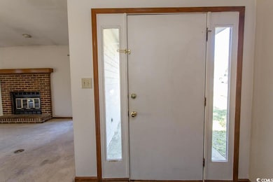 Carpeted foyer entrance with a fireplace