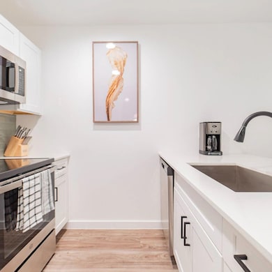 Kitchen featuring light countertops, white cabinet