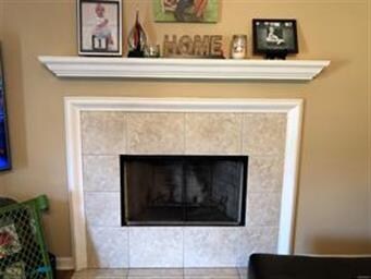 Fireplace has tile surround and classic shelf mant