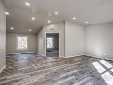 Spare room with vaulted ceiling, a textured ceilin