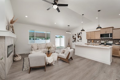 Living area featuring a tile fireplace, light wood finished floors, a ceiling fan, lofted ceiling, and recessed lighting
