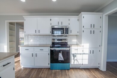 Kitchen featuring white cabinets, decorative backs