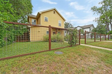 Back of property featuring fence, a lawn, and a g