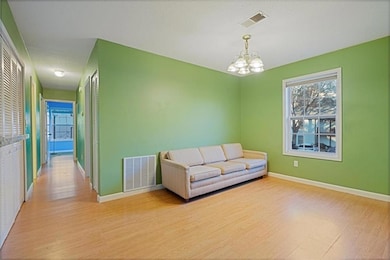 Living area with a textured ceiling, light wood-ty