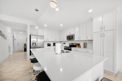 Kitchen featuring a breakfast bar area, white cabinetry, pendant lighting, appliances with stainless steel finishes, and light tile patterned flooring