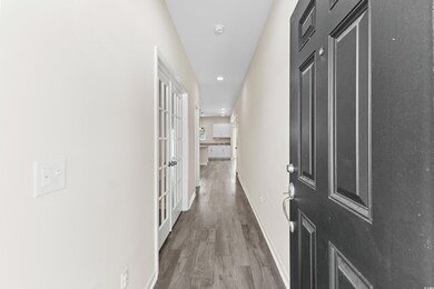Corridor with hardwood / wood-style floors